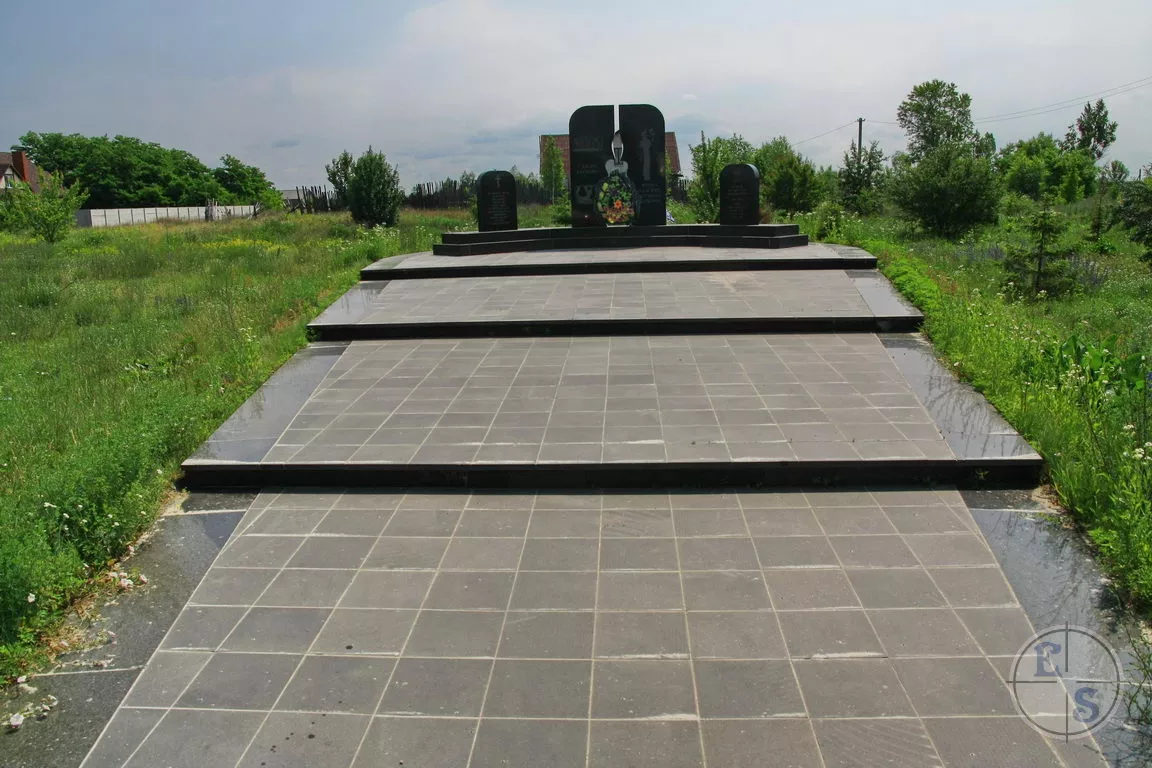 Доріжка з плитки до меморіалу серед трави