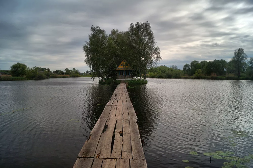 Old footbridge to the island on the pond in Staryi Solotvyn