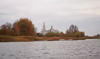 Білий храм у селі Нобель над водою серед осінніх дерев
